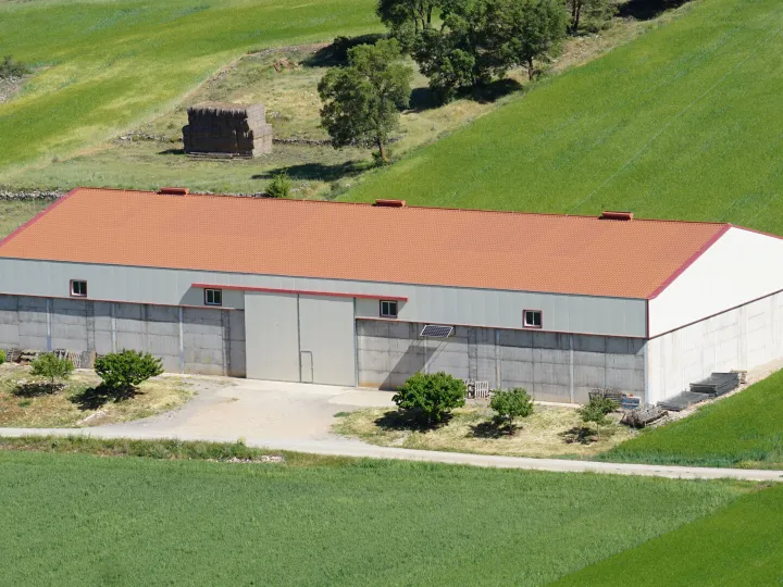 Overhead view of a large barn with a red roof