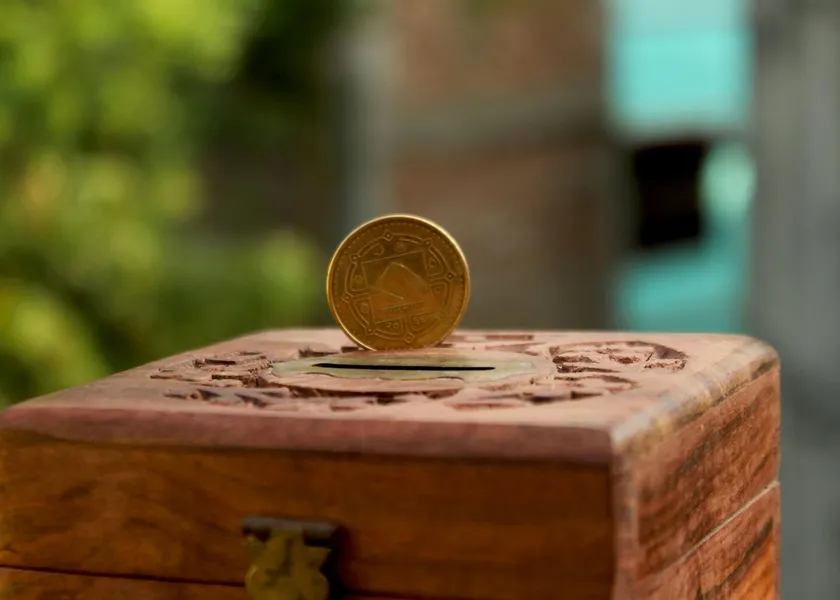 Close-up of a golden coin resting on a carved