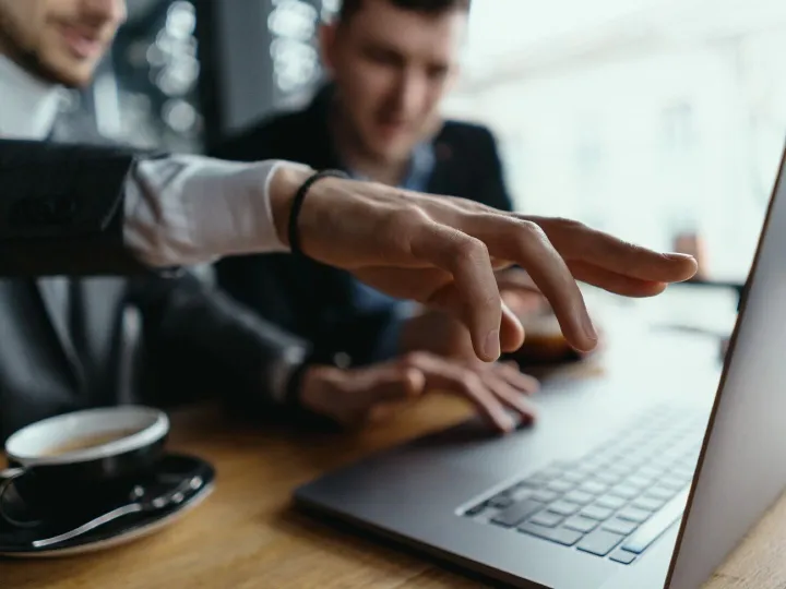 Two businessmen pointing laptop screen while