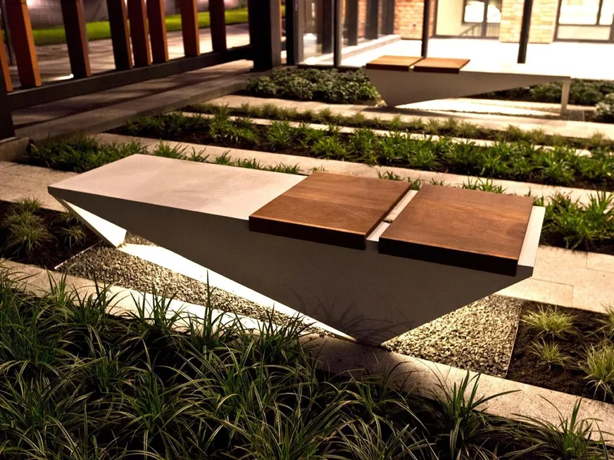 Modern concrete and timber bench set among ornamental grasses and gravel