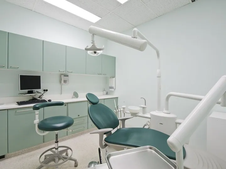 Modern dental practice treatment room with chair and equipment
