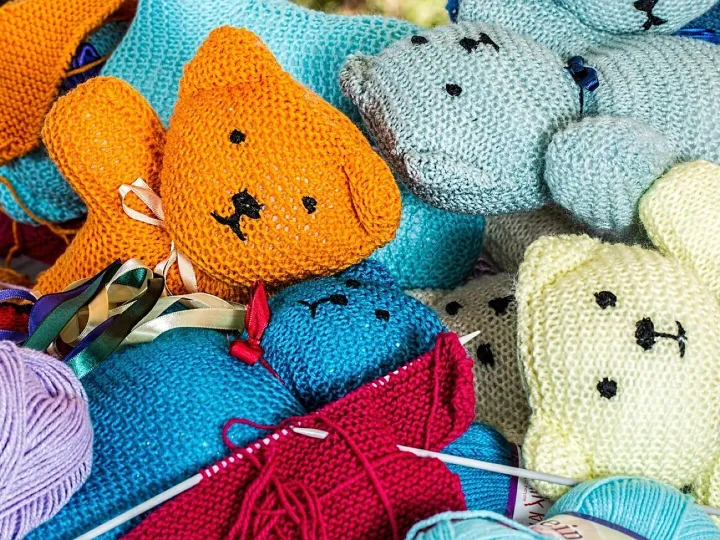 Hand-knitted woollen figures with knitting needles and balls of wool