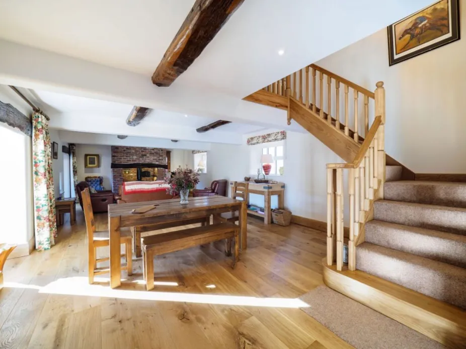 The dining area at Otters Retreat with a table seating eight and the oak staircase beyond
