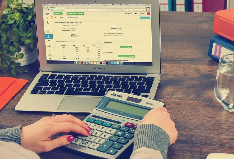 Financial documents, a calculator and binders on an office desk