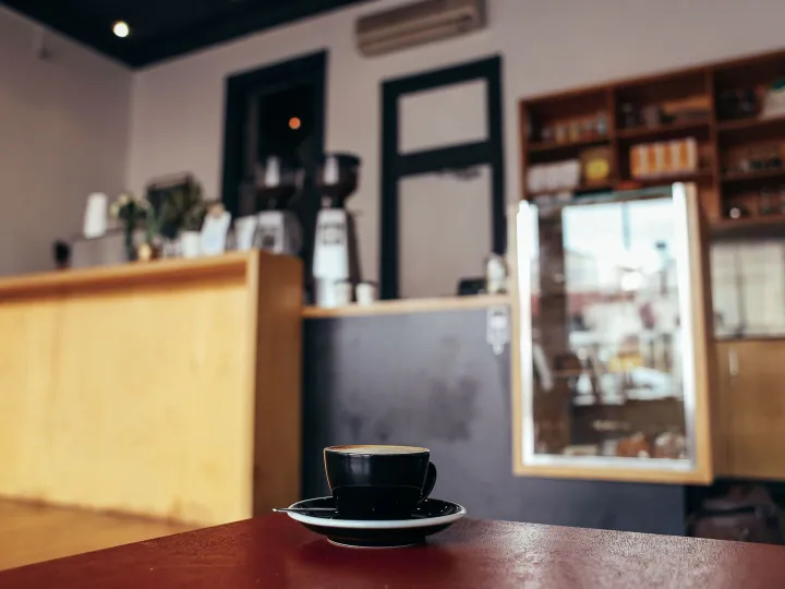 A quiet independent cafe with an empty table and a cup of coffee