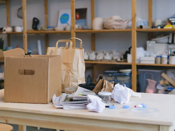 Packing boxes and paper bags piled on a table in a small business workspace
