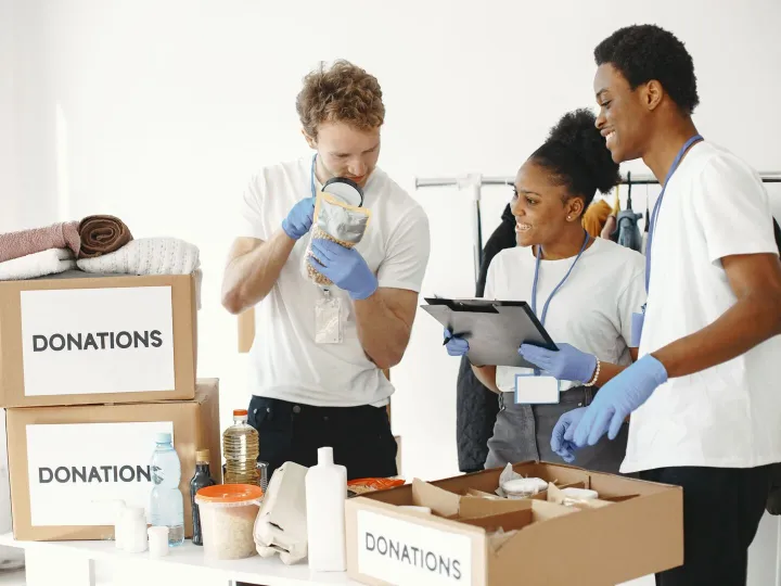 Volunteers sorting donated food and clothing into boxes at a charity