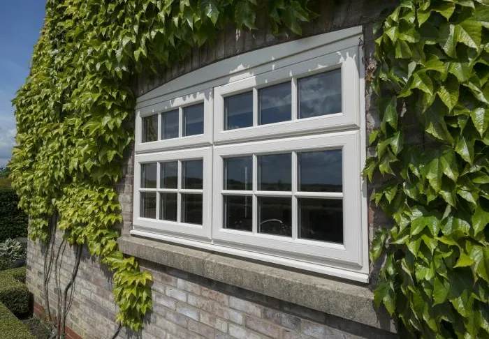 White uPVC window with ivy covered wall