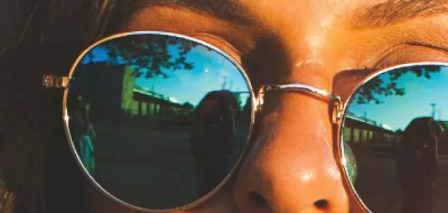 Woman with gold-rimmed reflective sunglasses