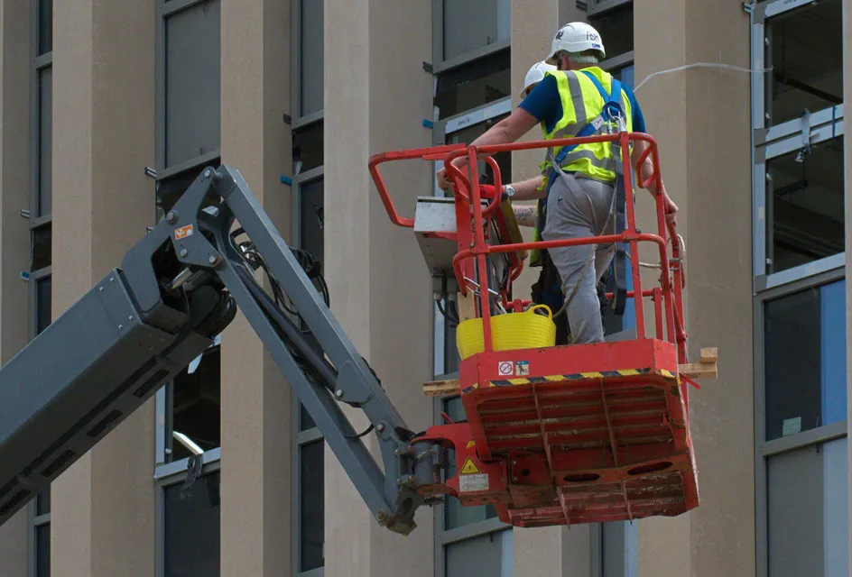 Worker painting on a cherry picker