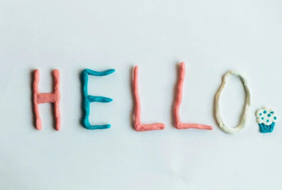 Creative hello greeting spelled out with colorful clay on a white background.