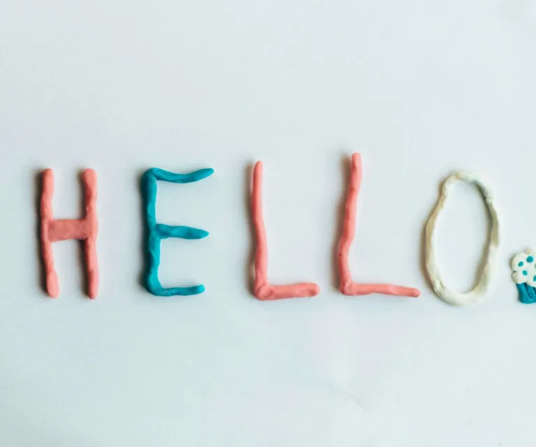 Creative hello greeting spelled out with colorful clay on a white background.