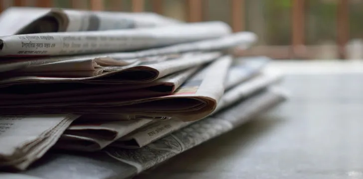 A close-up of a stack of newspapers resting on a