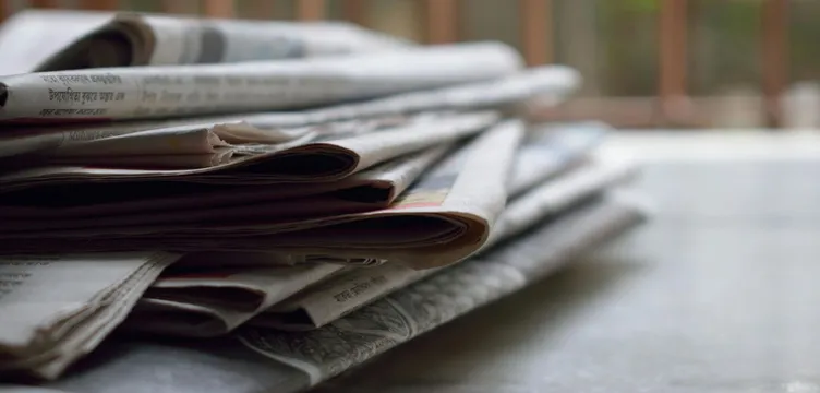 A close-up of a stack of newspapers resting on a