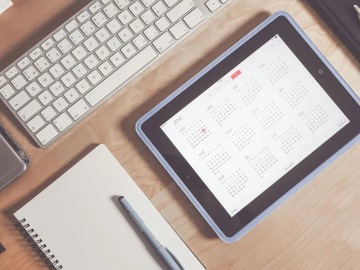 A tidy desk setup featuring a tablet displaying a