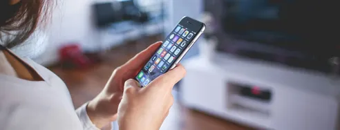 Woman browsing smartphone indoors, highlighting