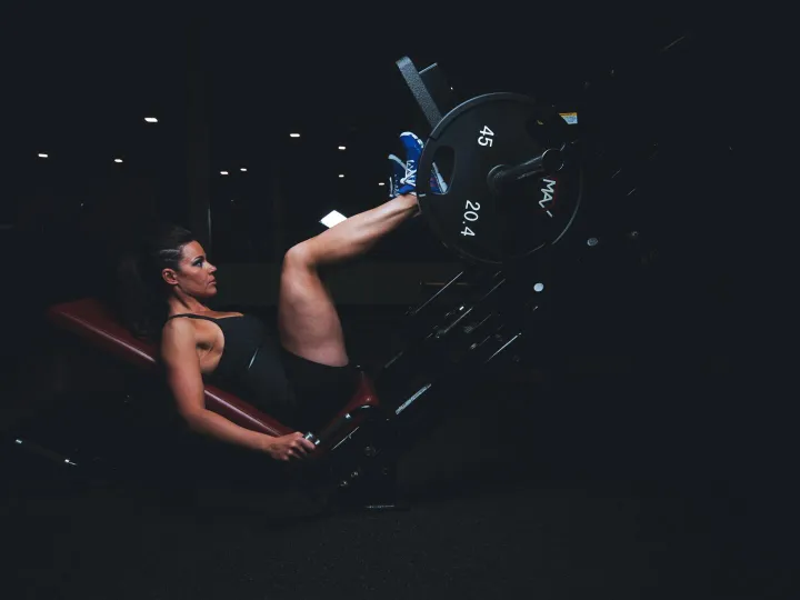 A woman engages in an intense leg press workout at