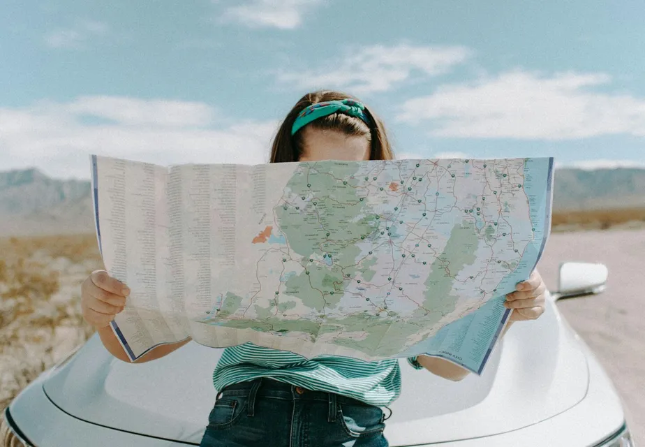 A woman holds a map while traveling through the
