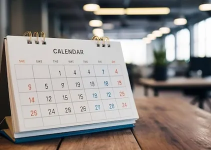 White paper desk calendar on wood table top with