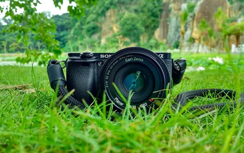 Camera with Carl Zeiss lens on grass, surrounded