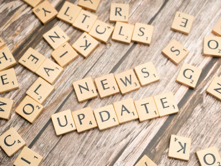 Scrabble tiles spelling 'News Update' on a wooden
