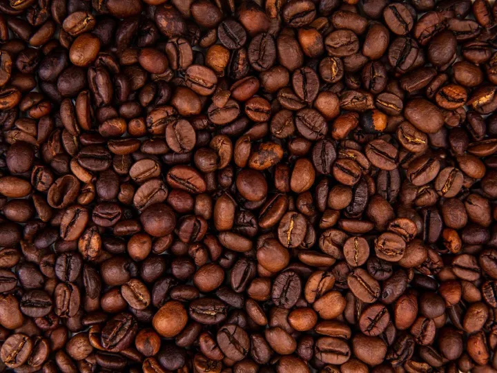 Close up view of dark fresh roasted coffee beans on coffee b