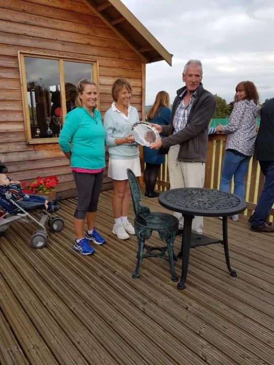 Current Chairman Chris Edwards presents the trophy to the Ladies Doubles winners Karen Elliott and Rowena Okell 2018 20180909_174045
