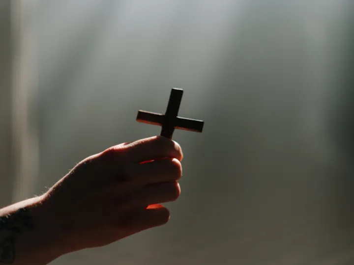A Person Holding a Cross