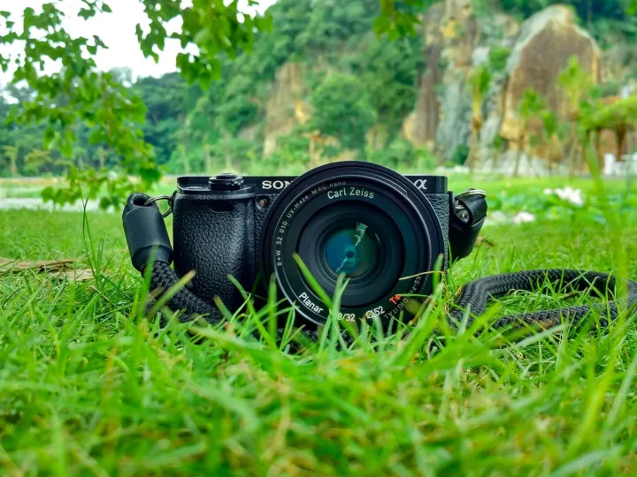 Camera with Carl Zeiss lens on grass, surrounded