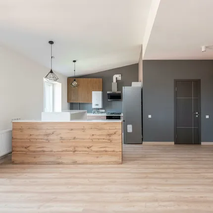 Explore a stylish and minimalistic open-plan kitchen with wood accents and modern design.