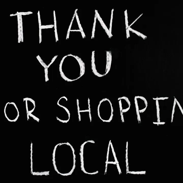 A handwritten chalkboard thanking customers for supporting a local business