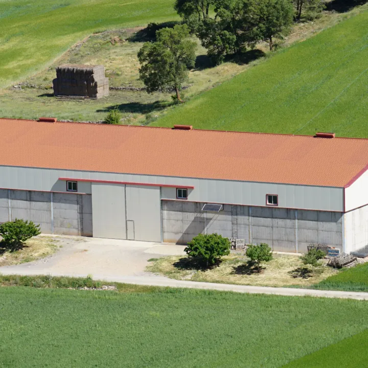 Overhead view of a large barn with a red roof