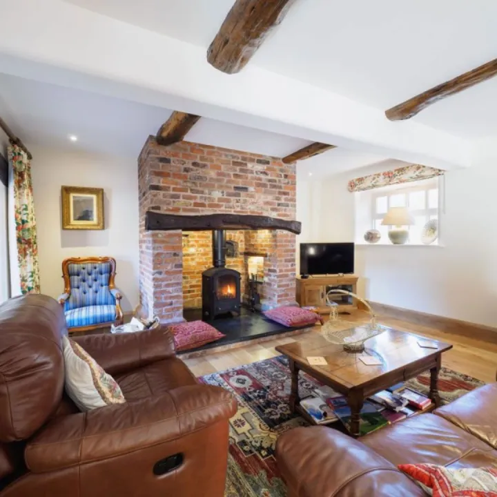 The lounge at Otters Retreat with an inglenook fireplace and log burning stove