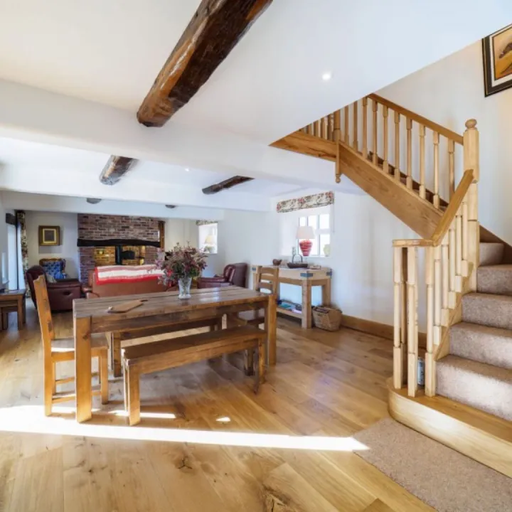 The dining area at Otters Retreat with a table seating eight and the oak staircase beyond