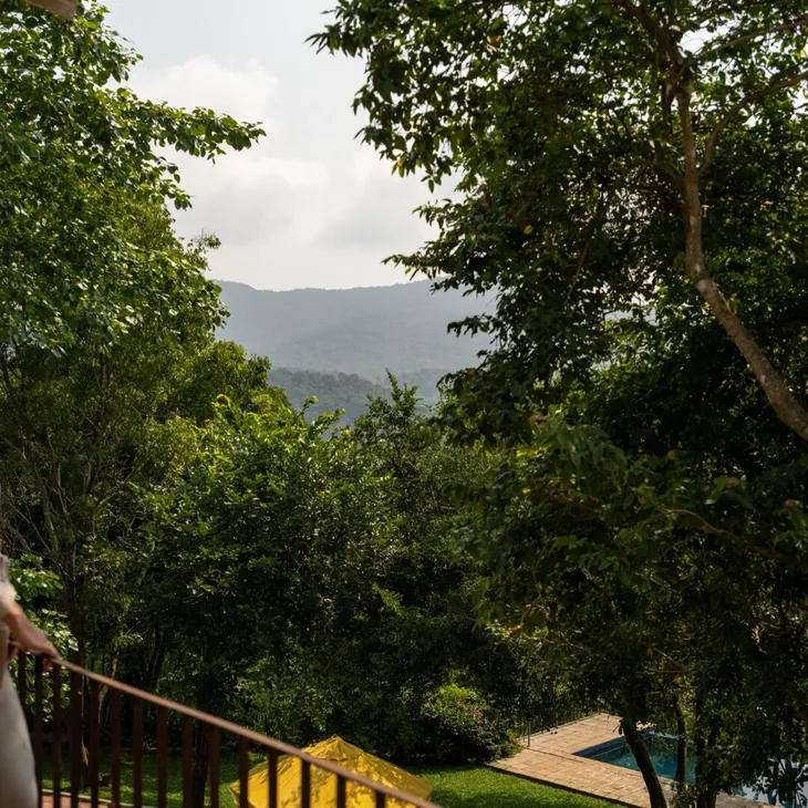 A guest on the 360 View Suite balcony looking towards the mountains at Peacock Hill Sigiriya