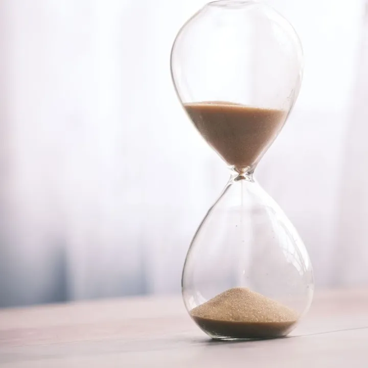 Minimalist hourglass filled with sand symbolizing