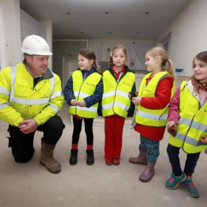 Redrow Site Manager Wayne Williams showing Phoebe Tomlinson, Elizabeth Lord, Aimee Williams and Nia Manson from Tattenhall Rainbows around Redrow's Meadow Brook development. credit: leeboswellphotography.com
