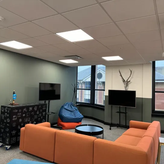 Office casual meeting area with orange sofas