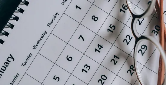 A close-up of a January calendar with eyeglasses