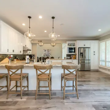 Bright and spacious kitchen interior featuring bar stools and modern design elements.