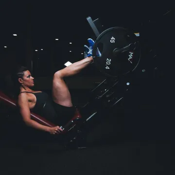 A woman engages in an intense leg press workout at