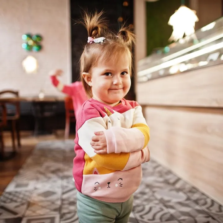 Young girl in cafe choose a dessert from shop window