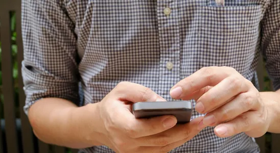 Close-up of a man using a smartphone, focusing on