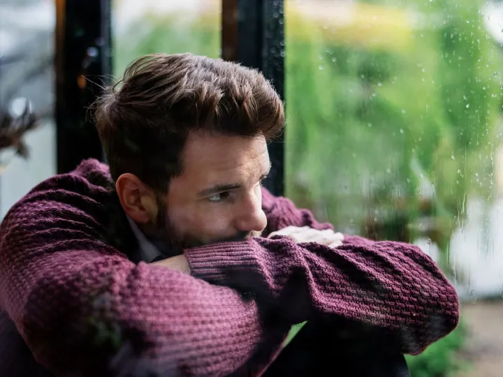 Thoughtful man looking out the window