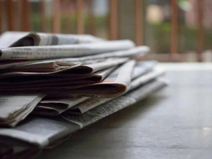 A close-up of a stack of newspapers resting on a