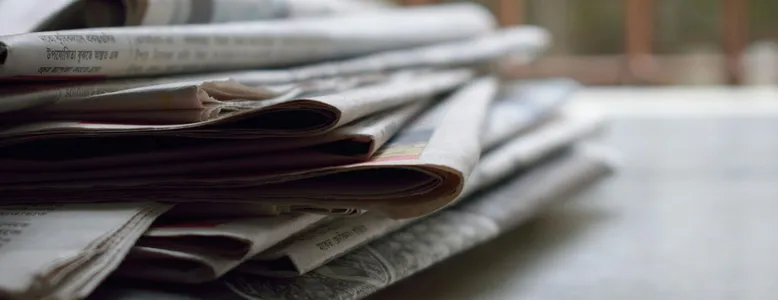 A close-up of a stack of newspapers resting on a