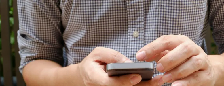 Close-up of a man using a smartphone, focusing on