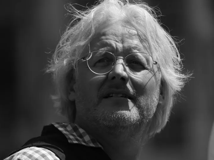 Black and white portrait of an elderly man wearing glasses in Brussels.