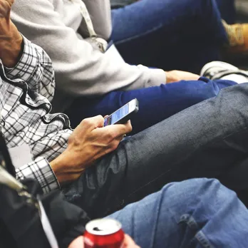 People sitting at a conference casually checking