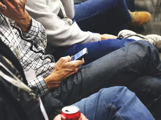 People sitting at a conference casually checking